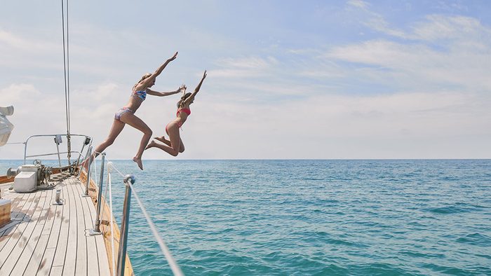 Happy People, two people jumping off of a boat
