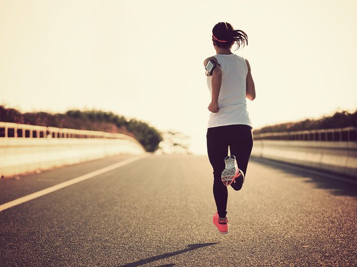 Run club, woman runs on an open road