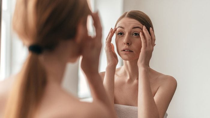 Breast Cancer Advancements, woman looking at herself in the mirror