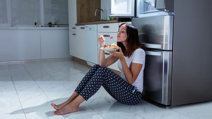 How Sugar Affects Sleep, woman sitting on floor eating