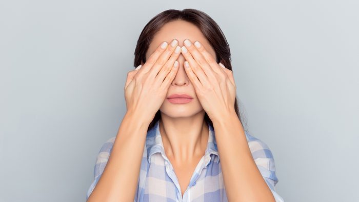 woman covering her face with hands eyes
