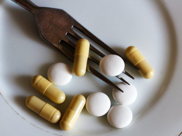 capsules and pills on plate with fork, diet and weight loss, idea