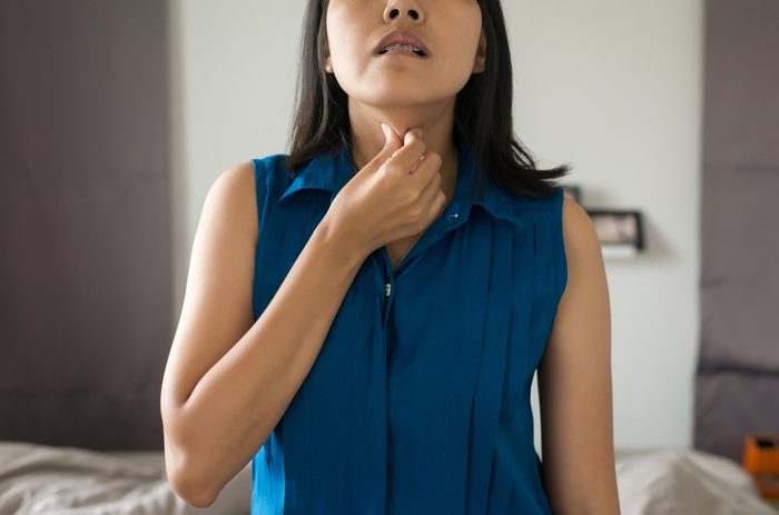 Woman have a sore throat,Female touching neck with hand,Healthcare Concepts