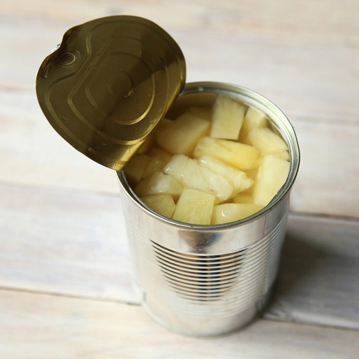 Opened tin can of canned pineapple pieces.