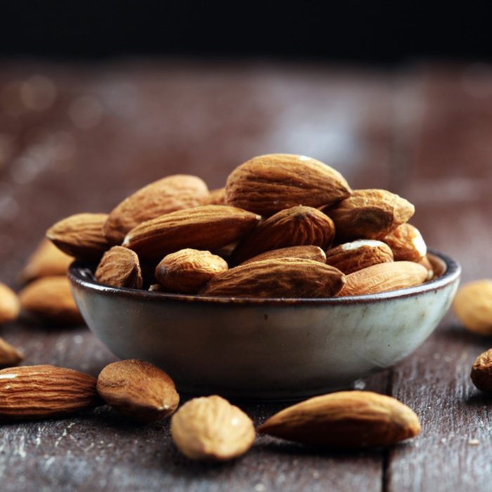 Almonds on a rustic wooden table and almond in bowl