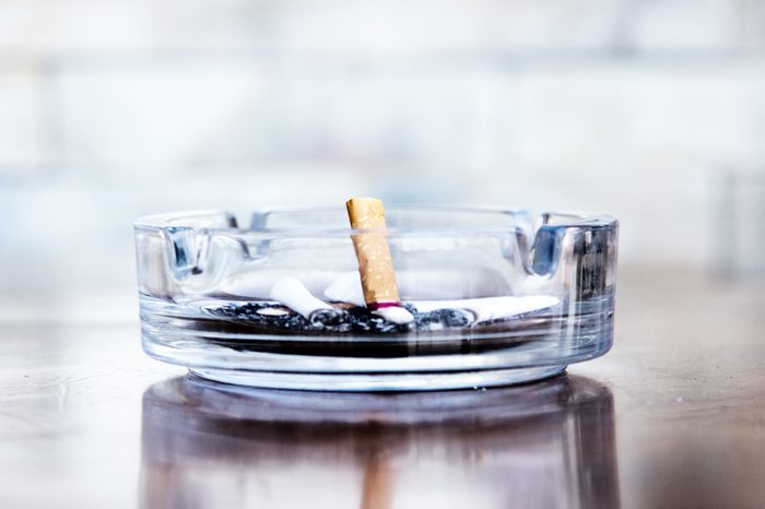Cigarette butts and ashtray in a glass, leave off smoking.
