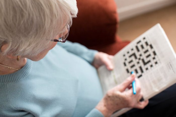 Senior Woman Doing Crossword Puzzle At Home