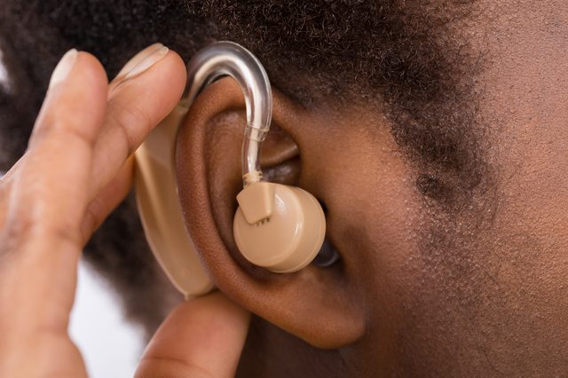 Close-up Of African Woman Wearing Hearing Aid In Ear