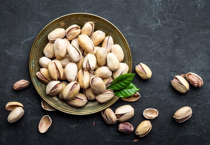 Pistachios nuts on dark background, top view, healthy snack