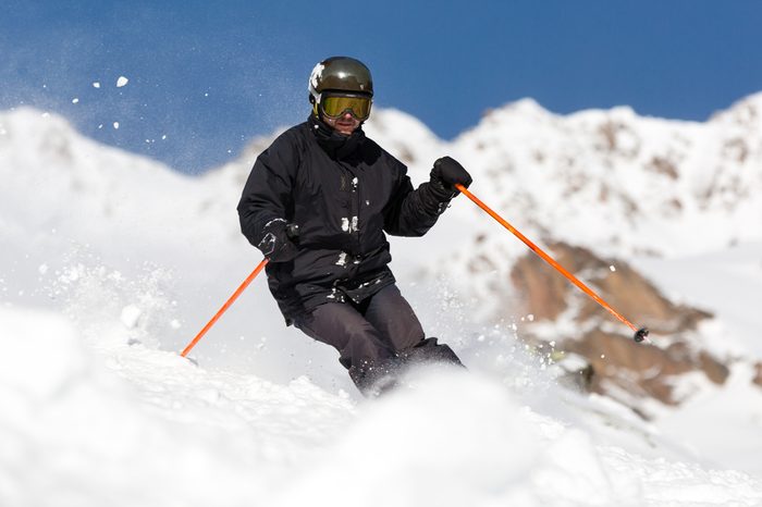 Male skier skiing in fresh snow on ski slope on a sunny winter day at the ski resort Soelden in Austria.