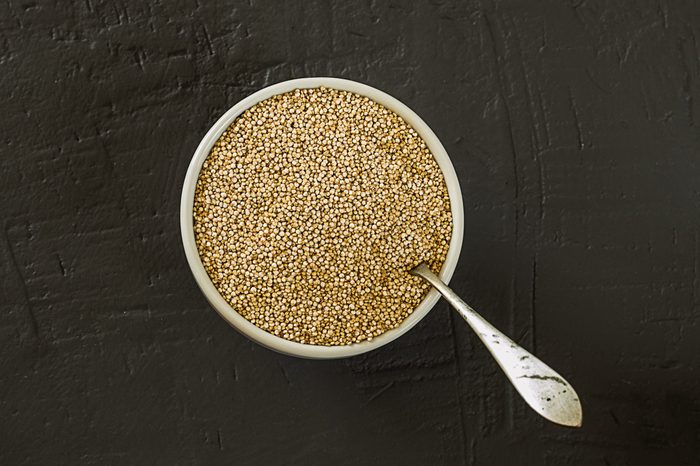 Spoon with quinoa seeds on table
