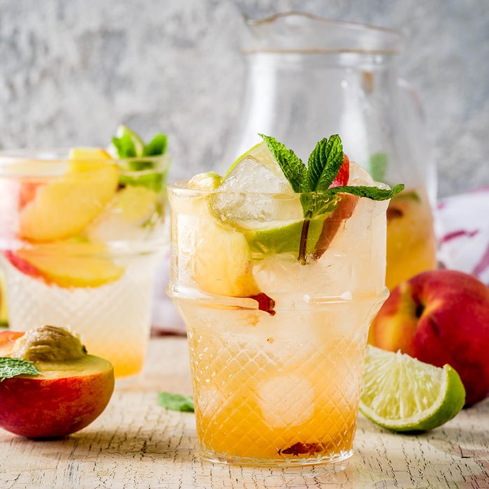 Peach and lime lemonade, mojito cocktail with fresh fruit garnish, om light concrete background copy space selective focus; Shutterstock ID 1139051825; Job (TFH, TOH, RD, BNB, CWM, CM): Taste of Home