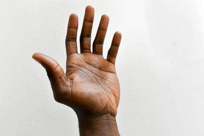 left hand of dark skin African man isolated on white background 
