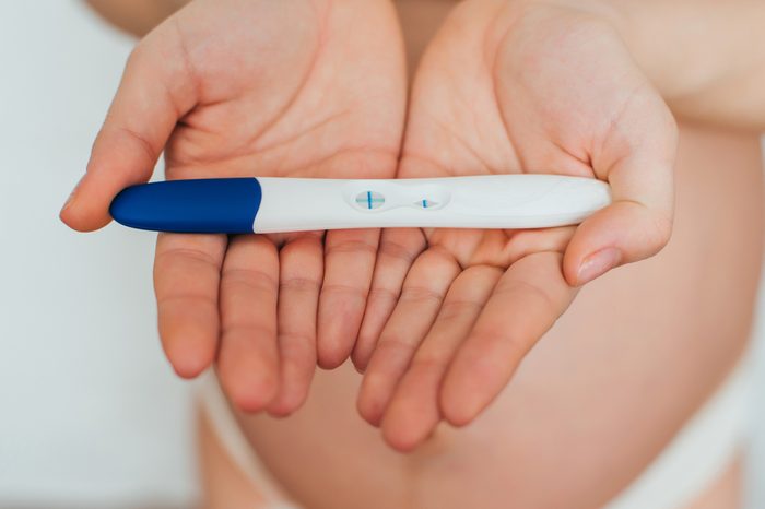 pregnancy test in the hands of a girl with a positive result close up