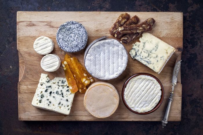 French Cheese Platter with Spanish Dulce de Membrillo as top view on a wooden board 