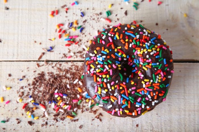 overhead studio shot of a donut with sprinkles on a wooden background unhealthy food concept 