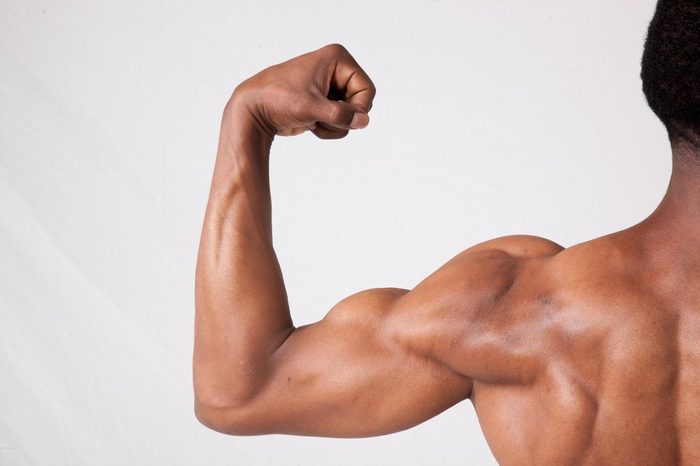 Strong Black man flexing his arm, from the back 