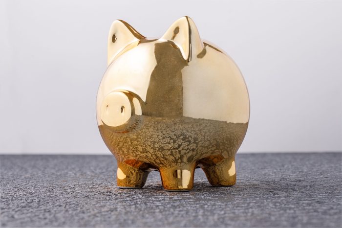 Pig money box golden on black background concept of financial insurance, protection, safe investment or banking. Close-up.