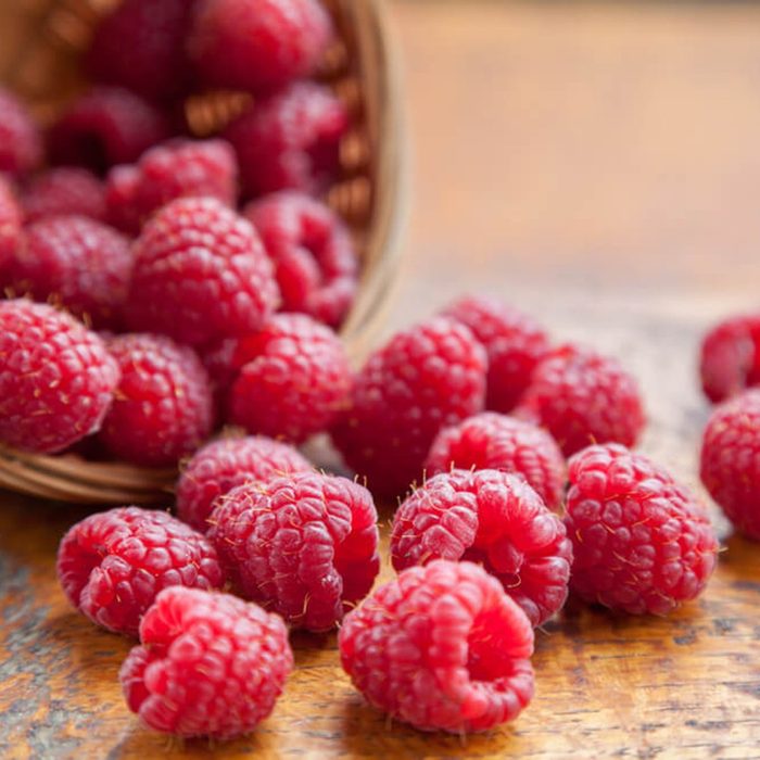 Raspberries falling out of a basket