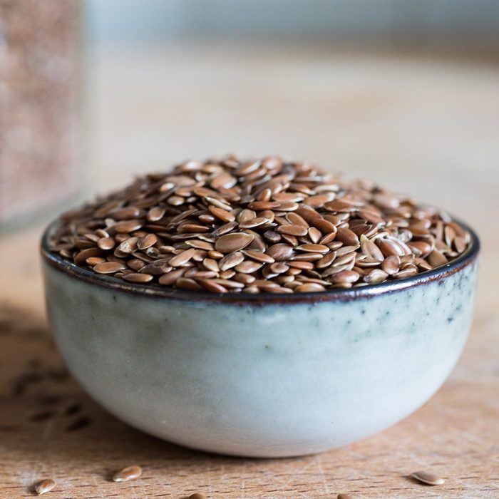 bowl on wooden table with superfood healthy linseed flaxseed grain cereal