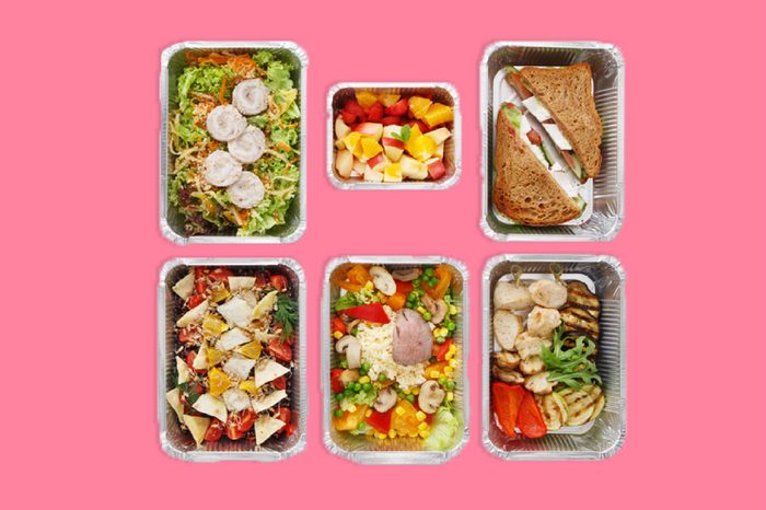 Healthy food delivery, daily meals and snacks. Diet nutrition, vegetables, meat and fruits in foil boxes. Top view, flat lay at white wood with copy space