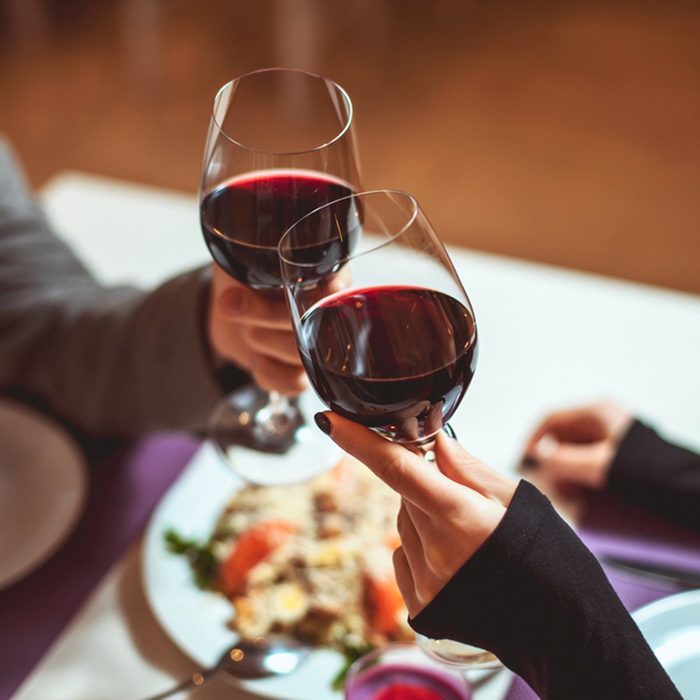 Beautiful young couple with glasses of red wine in luxury restaurant; Shutterstock ID 364873787