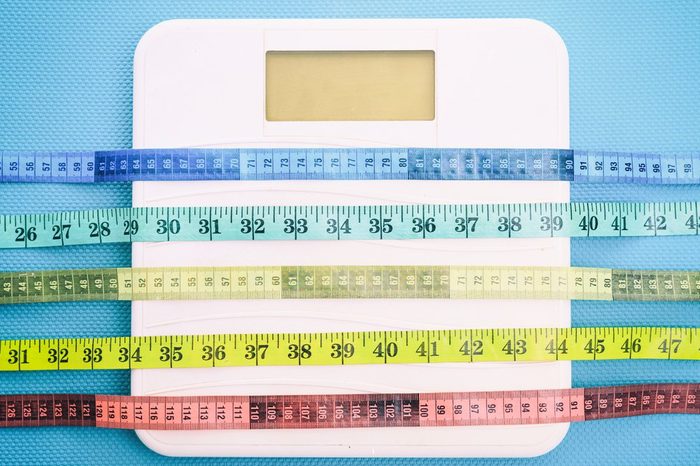 Bathroom scale and measure tapes on a blue background