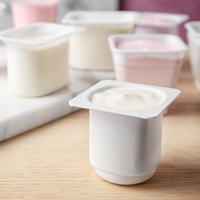 Plastic cup with tasty yogurt on table