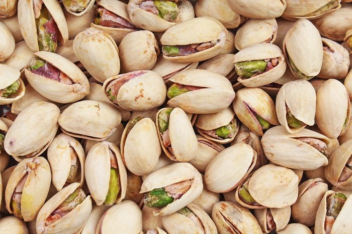Pistachio texture. Nuts. Green fresh pistachios as texture. Roasted salted pistachio nuts healthy delicious food studio photo.