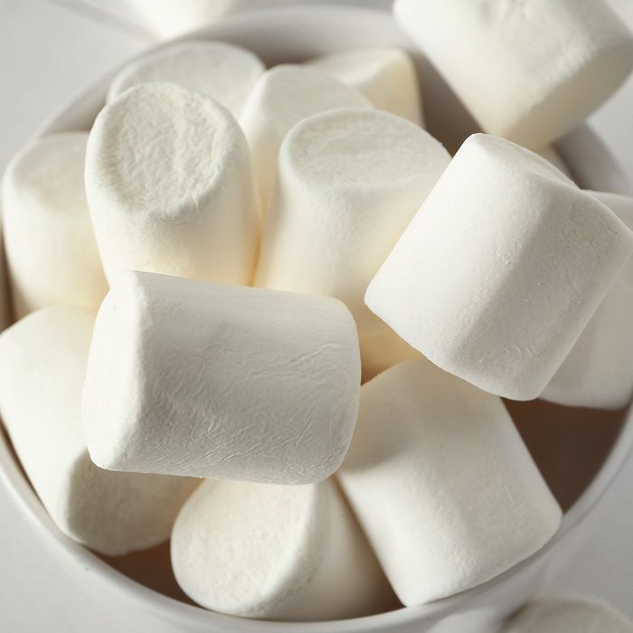 Bowl with tasty marshmallows on white table