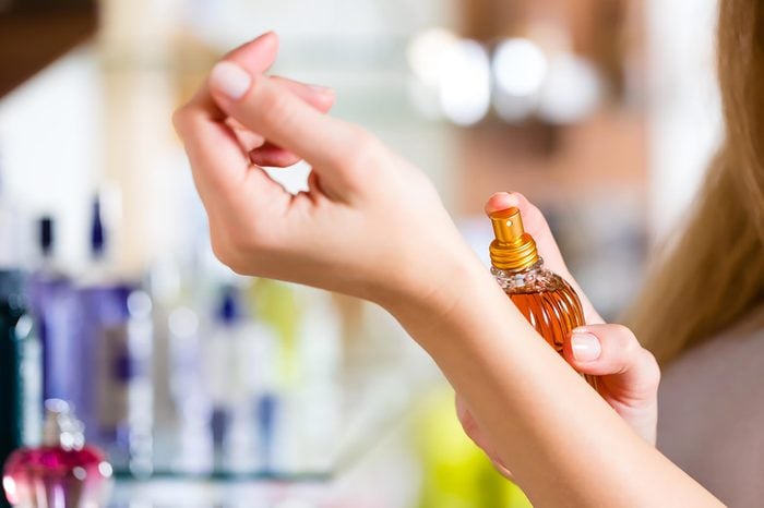 Woman applying perfume. | These skin care ingredients can cause breakouts.
