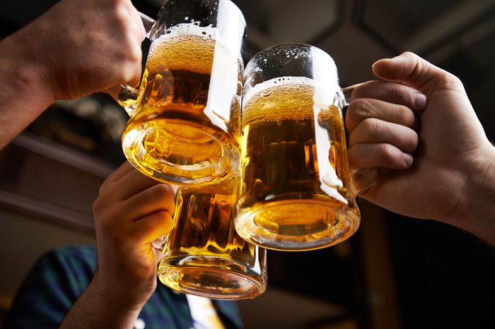Boost Male Fertility | Hands clinking together three mugs of beer in a toast