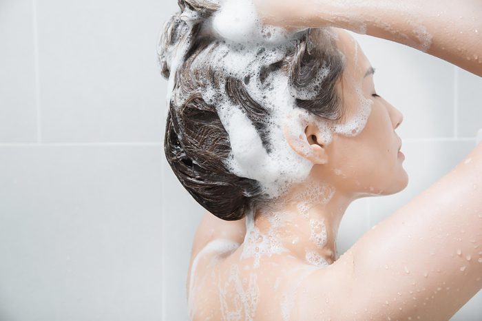 A woman shampooing her hair in the shower. | These skin care ingredients can cause breakouts.