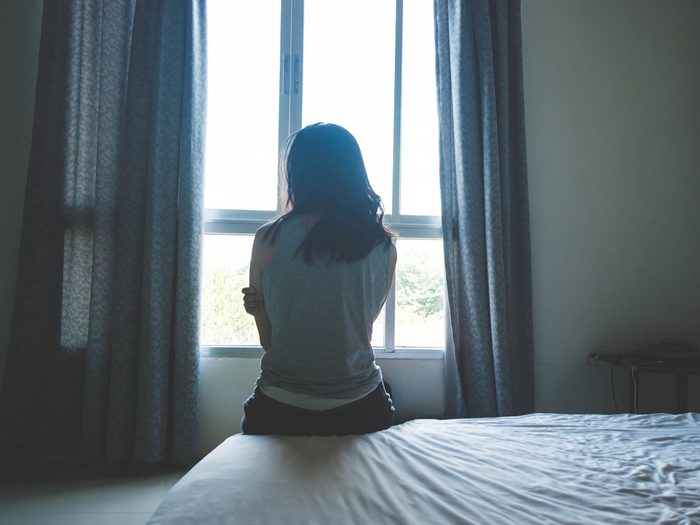 depression risk - woman sitting on her bed