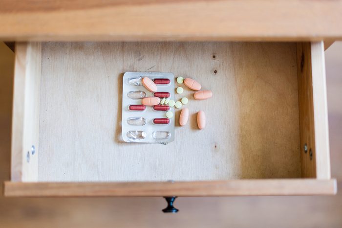 top view of pile of pills in open drawer of nightstand