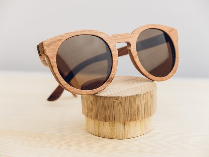 Wooden sunglasses with cover on wooden background, wooden case