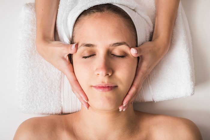 Anti-Aging Treatments | Spa concept. Face massage. Young woman getting spa treatment, close up
