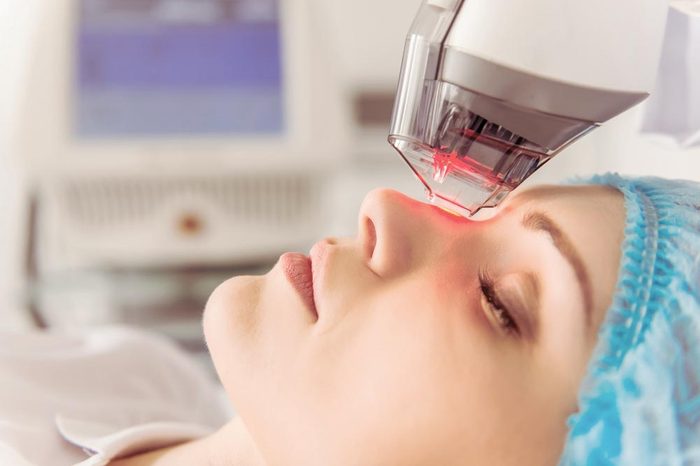Anti-Aging Treatments | Beautiful female patient is getting a face skin treatment while lying at cosmeticians office, close up