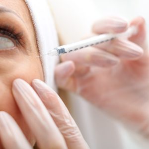 Professional beautician making botox facial injection