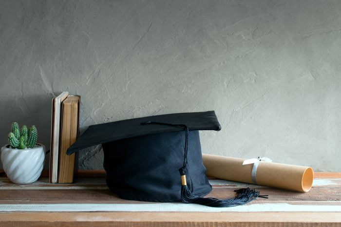 graduation cap, hat with degree paper on wood table graduation concept.
