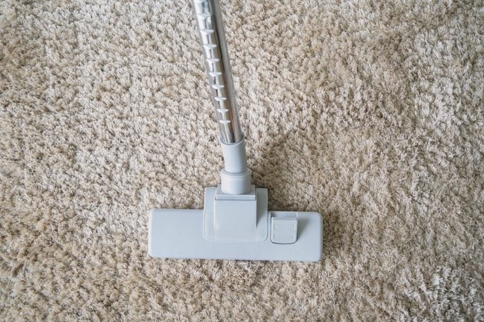 Modern vacuum cleaner vacuuming on carpet