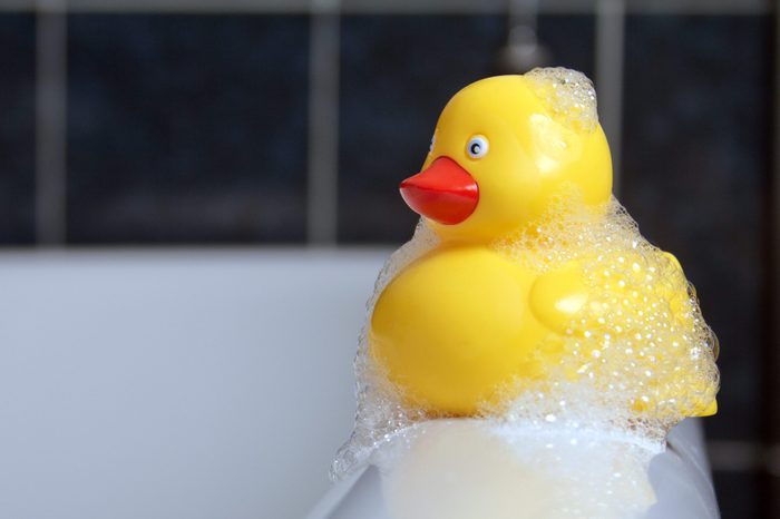 Rubber duck with bubbles sitting on bath edge