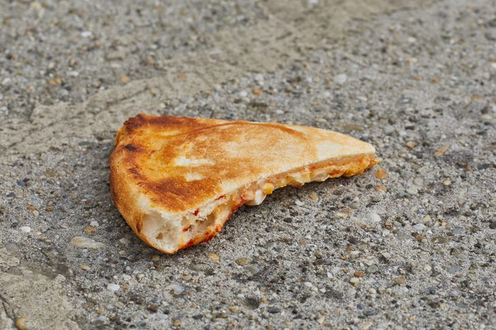 Pizza slice dropped on the ground