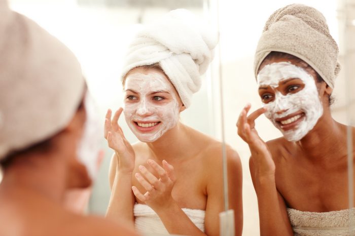 two young women applying face masks