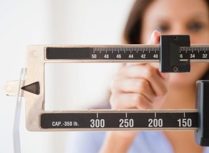 signs your body is in trouble | woman adjusting scale