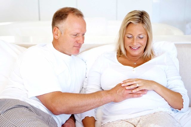 health myths gynecologists hear | man with hand on pregnant woman's belly