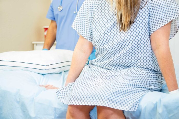 health myths gynecologists hear | woman sitting on exam table in gown
