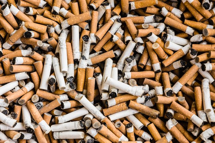 things that wreck your teeth | a lot of burnt cigarette butts with some ash