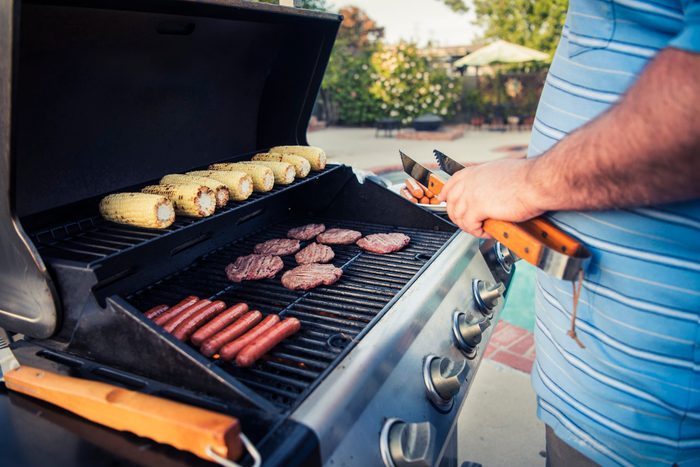 healthier grilling | man grilling meat and corn
