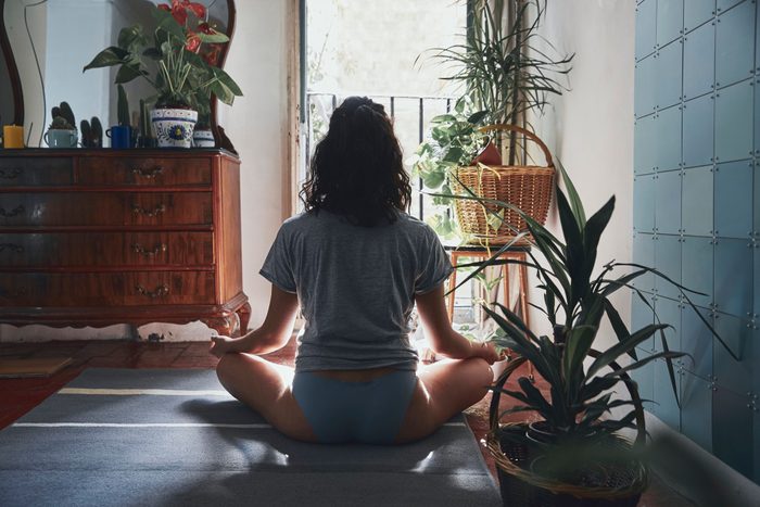 woman sitting on floor at home doing yoga